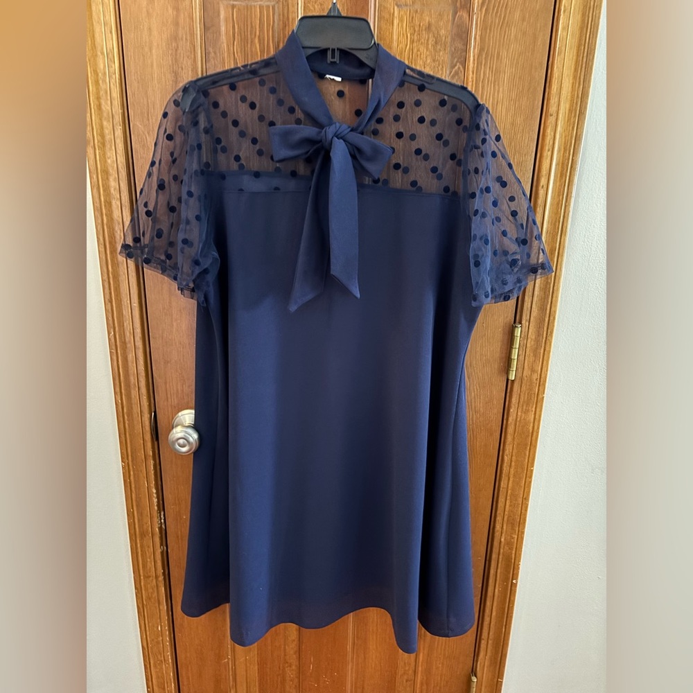 Short navy blue dress with mesh sleeves with polka dots and a tie front.
